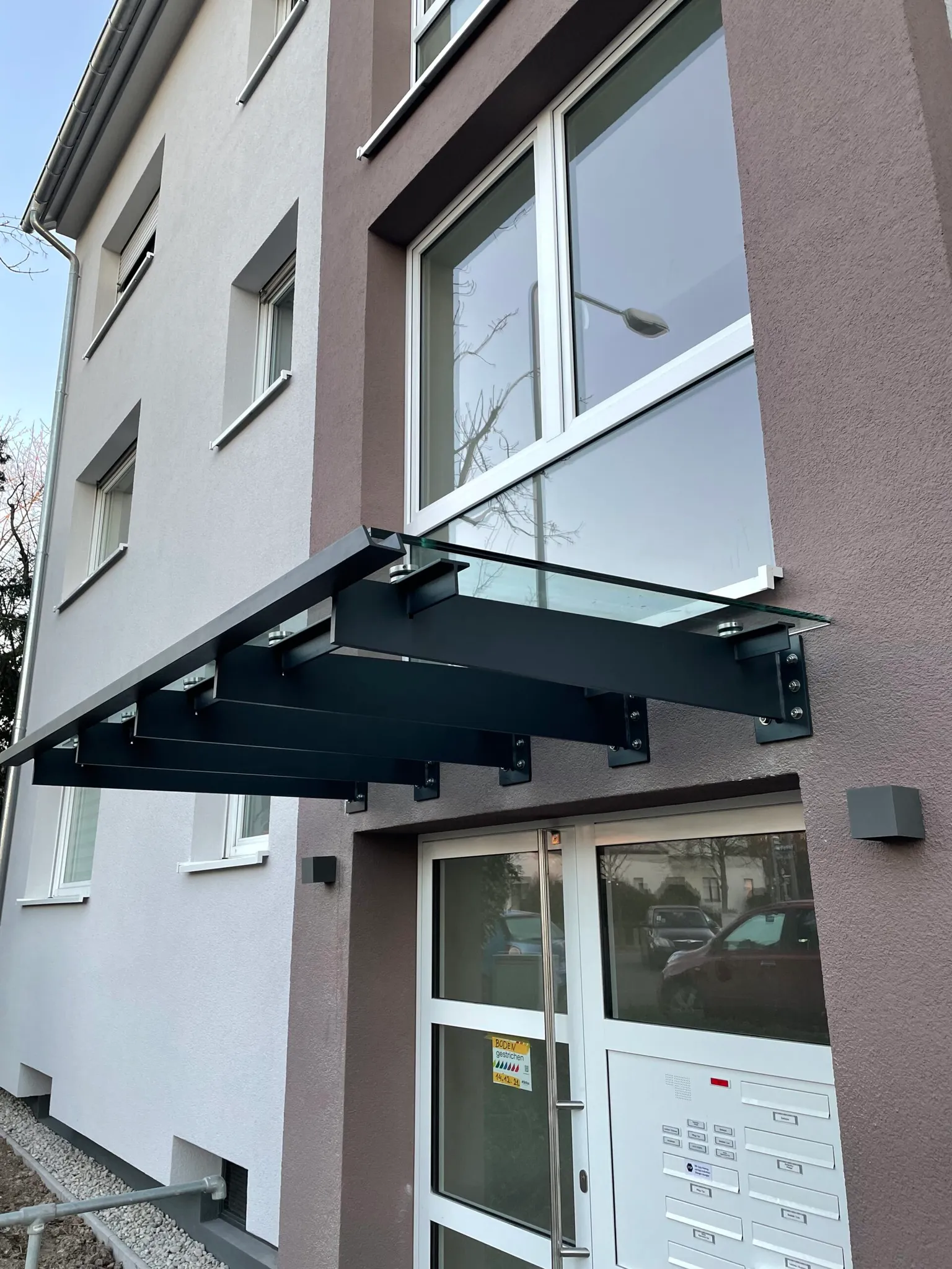 Modernes Vordach aus Glas und Stahl
